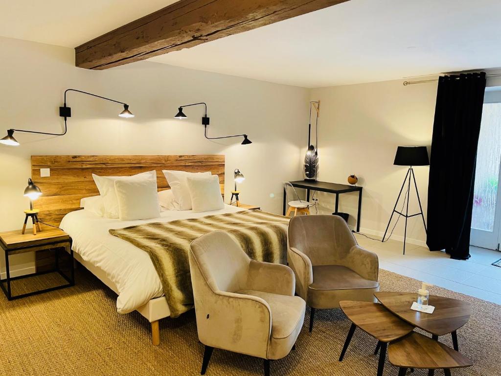 een slaapkamer met een groot bed en 2 stoelen bij Zewwelatreppler - La Grange aux Petits Oignons - Chambre Cigogne in Sélestat