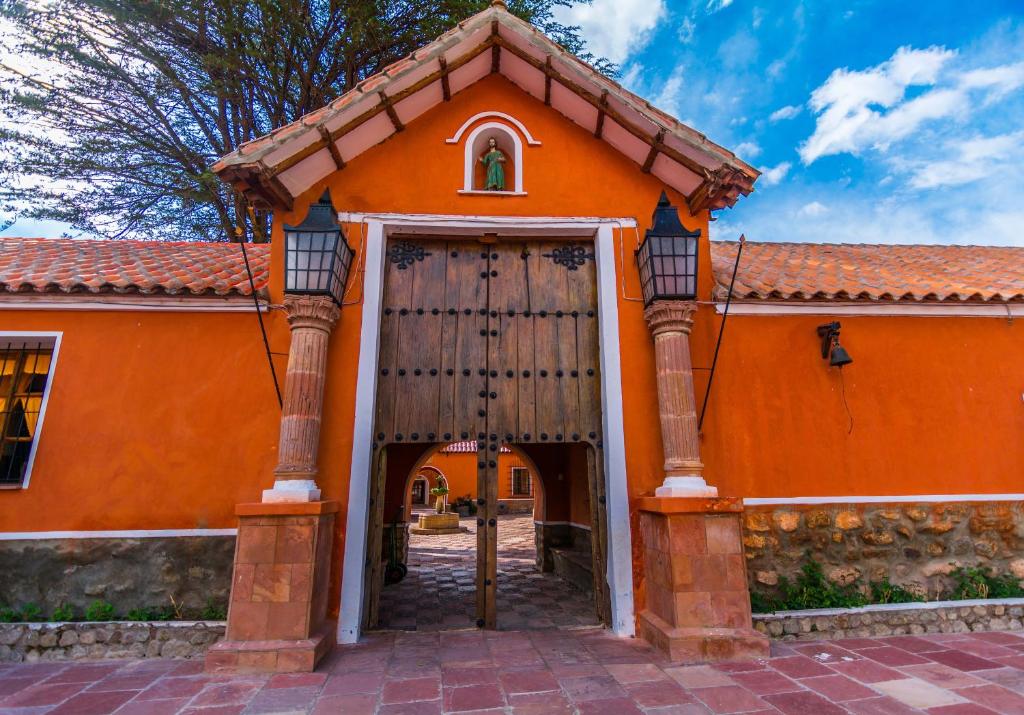 um edifício laranja com uma grande porta de madeira em Hotel Museo Cayara em Santa Lucía