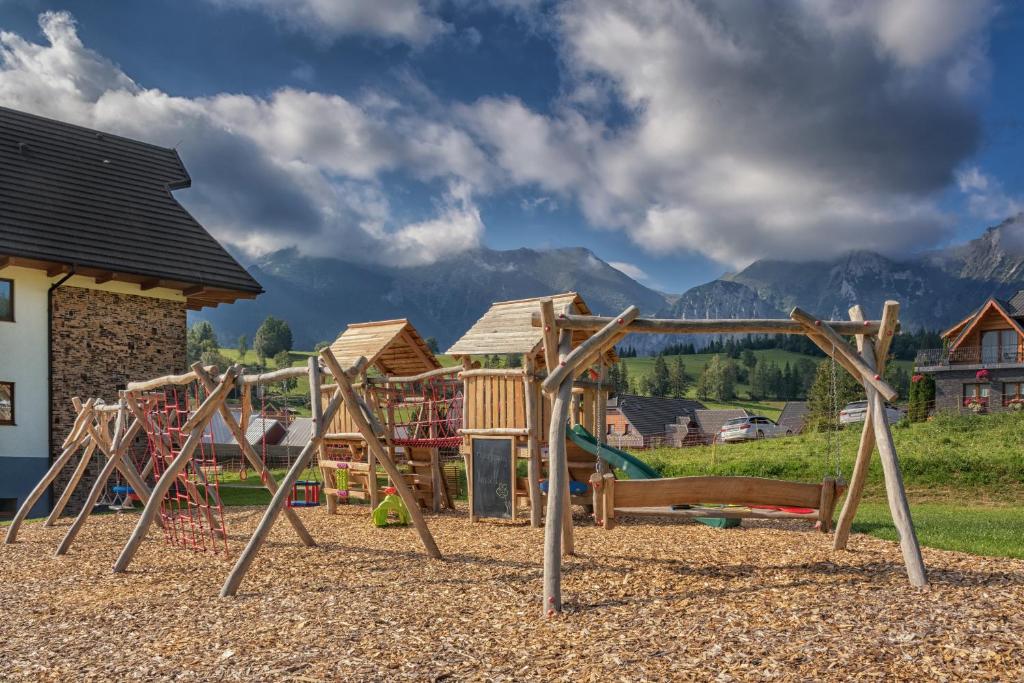 einen Spielplatz in einem Resort mit Bergen im Hintergrund in der Unterkunft Apartmany Krasvill in Ždiar