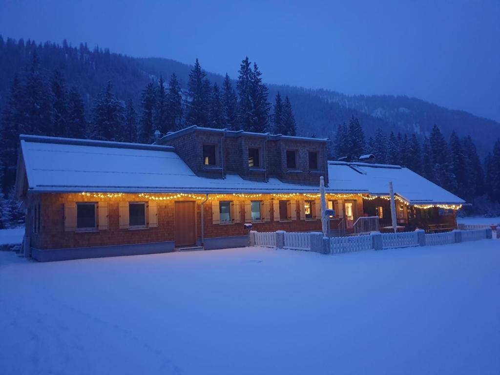 a house with lights on it in the snow at Ammerwald Alm in Plansee