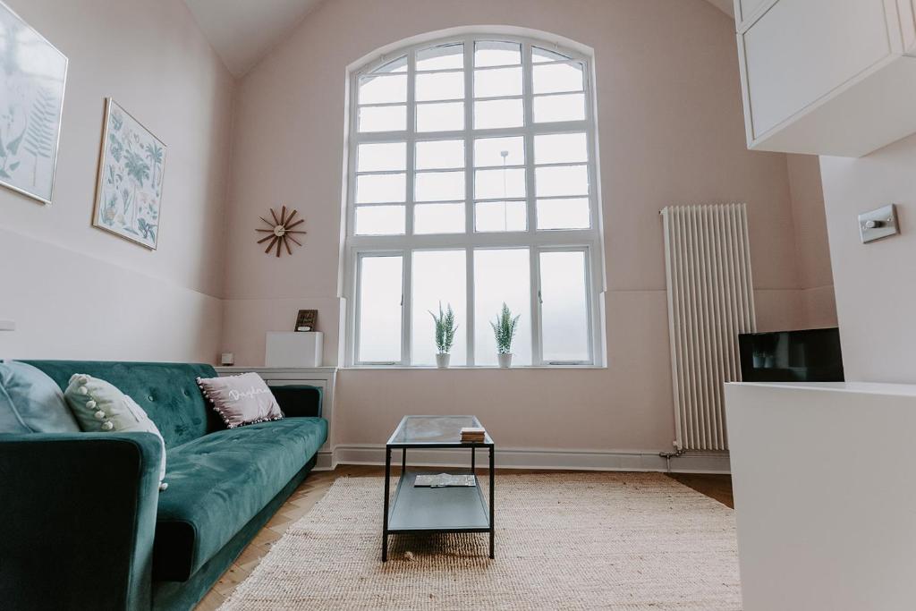 ein Wohnzimmer mit einem grünen Sofa und einem Fenster in der Unterkunft The Old Choir School in uphill Lincoln in Lincolnshire
