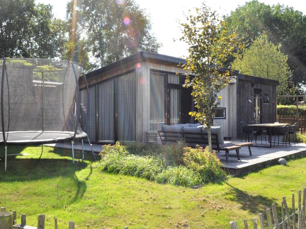 un cobertizo con un banco y una mesa en un patio en Serene chalet in Haulerwijk with enclosed garden and views, en Haulerwijk