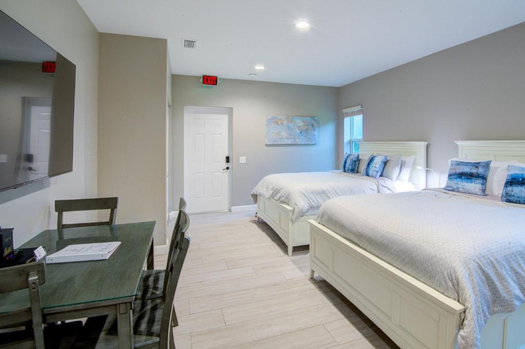 a bedroom with two beds and a table and a desk at HS#2- Modern Studio next to Premier Sports Complex in Bradenton
