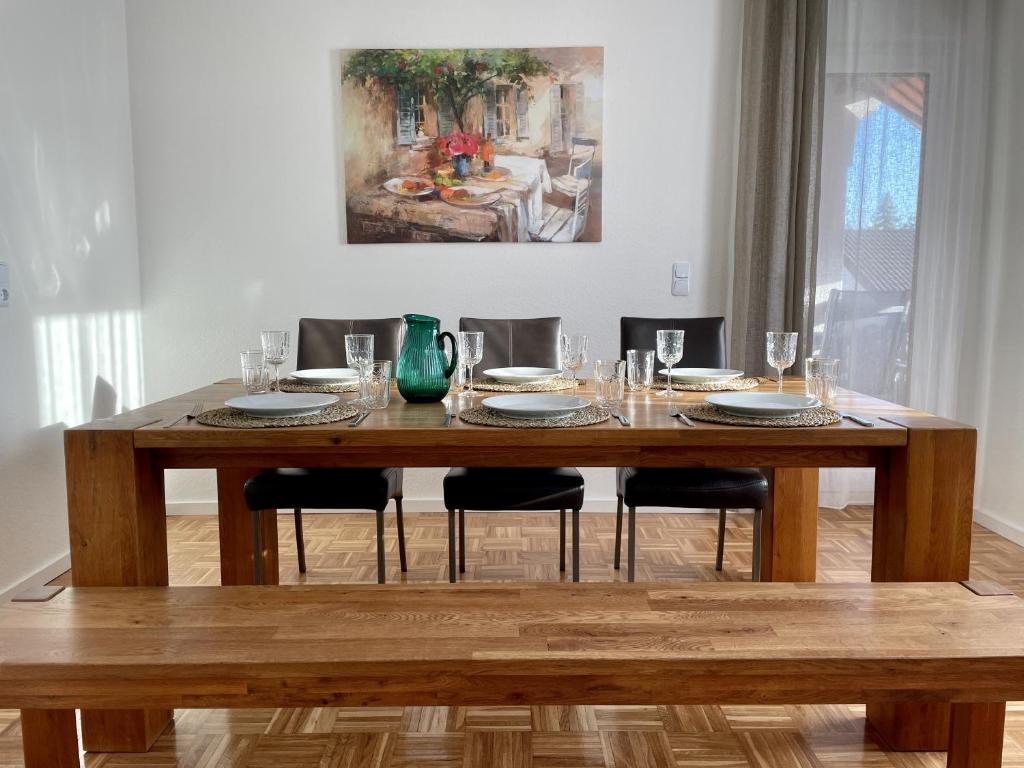 una mesa de madera con platos y vasos. en Hopfenglück, en Tettnang