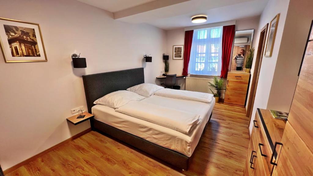 a small bedroom with a bed and a window at Hotel Zu den Drei Kronen in Seligenstadt