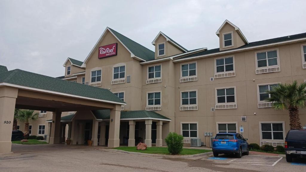 a hotel with a car parked in front of it at Red Roof Inn & Suites Midland in Midland