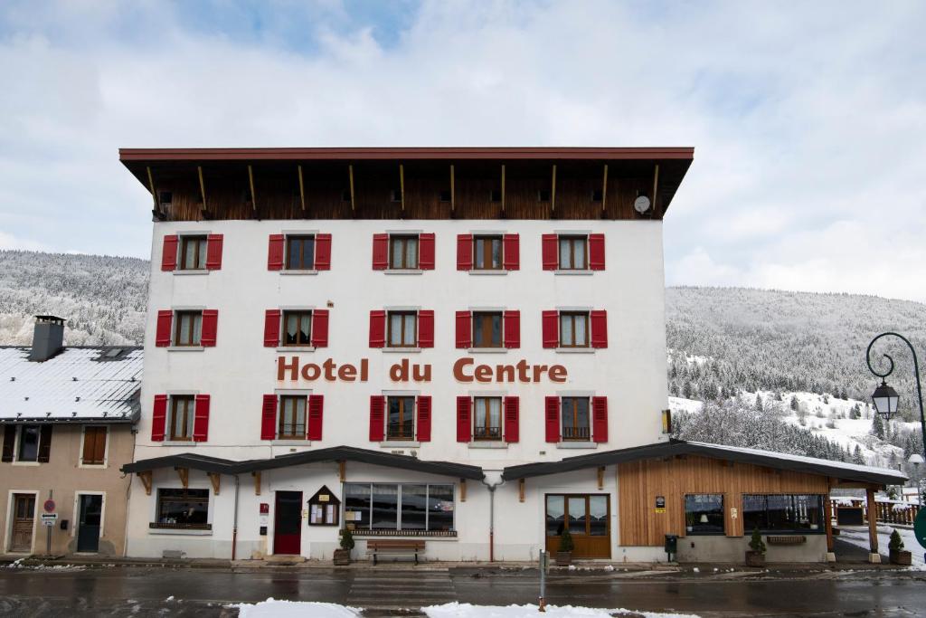 un edificio con finestre rosse e centro fluorescente dell'hotel di HOTEL RESTAURANT LE CENTRE a Lélex