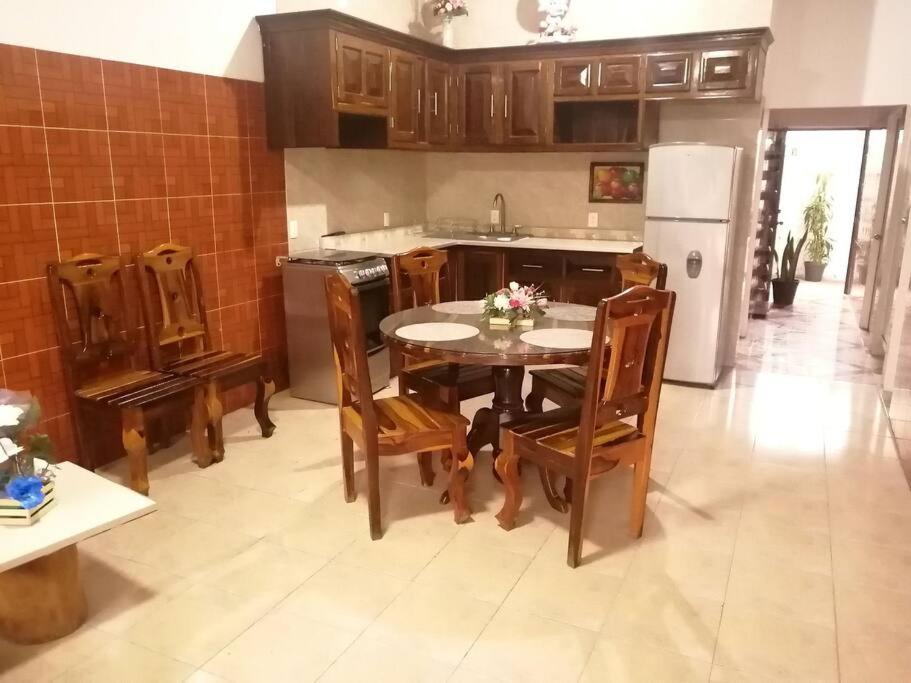 eine Küche mit einem Tisch und Stühlen sowie einem Kühlschrank in der Unterkunft Casa Maribel Lugar para descansar en ixtapa in Ixtapa
