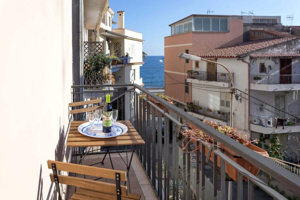 a table and chairs on a balcony with a view of the ocean at Il Fascino della Sirena - Sea House in Giardini Naxos