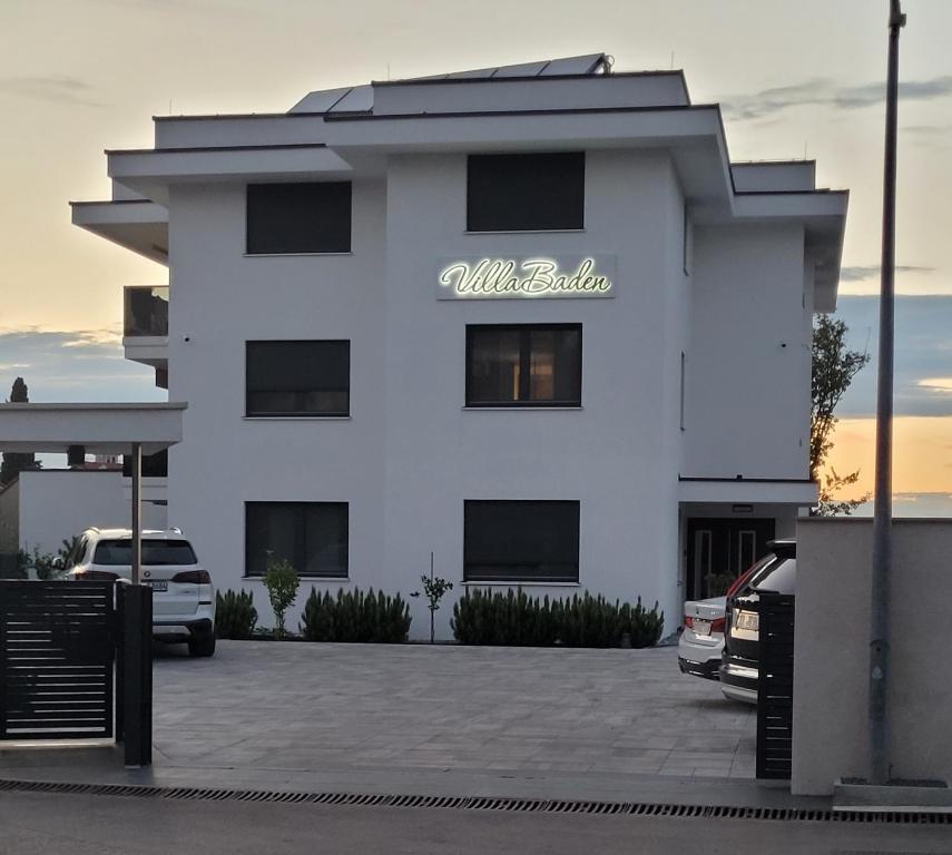 un edificio blanco con un cartel. en Villa Baden en Malinska