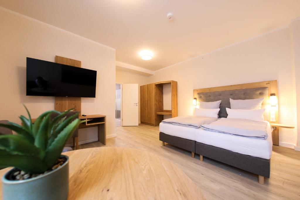 um quarto de hotel com uma cama e uma televisão de ecrã plano em 247 Selfcheckin Pferdemarkt em Leer