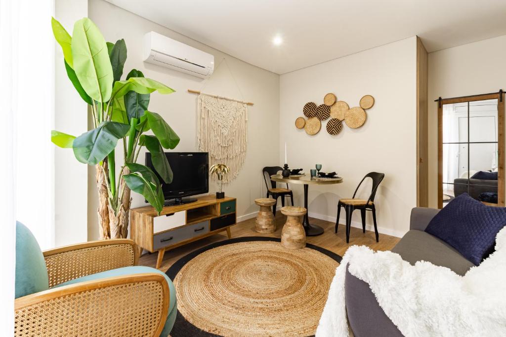 a living room with a couch and a tv at Porta 25 Guesthouse in Covilhã