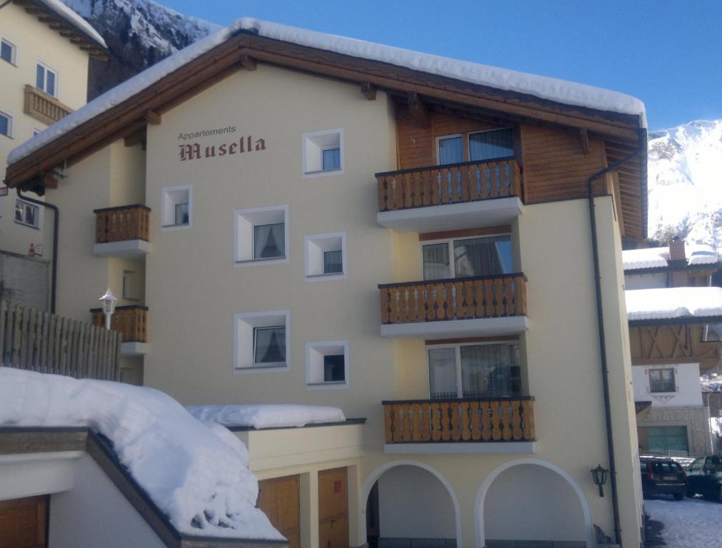 ein Gebäude mit Balkon und Schnee auf dem Dach in der Unterkunft Haus Musella in Samnaun