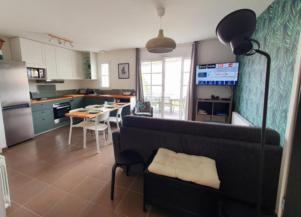 Il comprend un salon et une cuisine avec un canapé et une table. dans l'établissement Maison le Havre de la Gachère, 2 chambres, 2 salles d'eau, parking privé et jardin, à Brem-sur-Mer