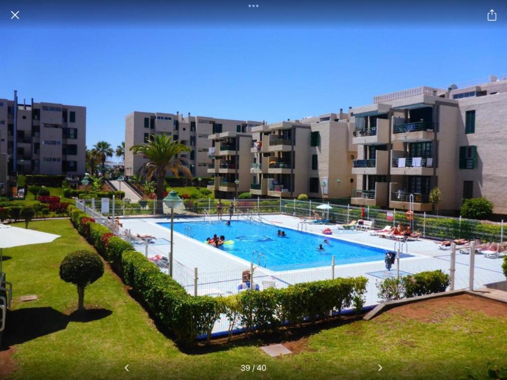 a large swimming pool in front of some apartment buildings at Las Viñas in Playa de las Americas