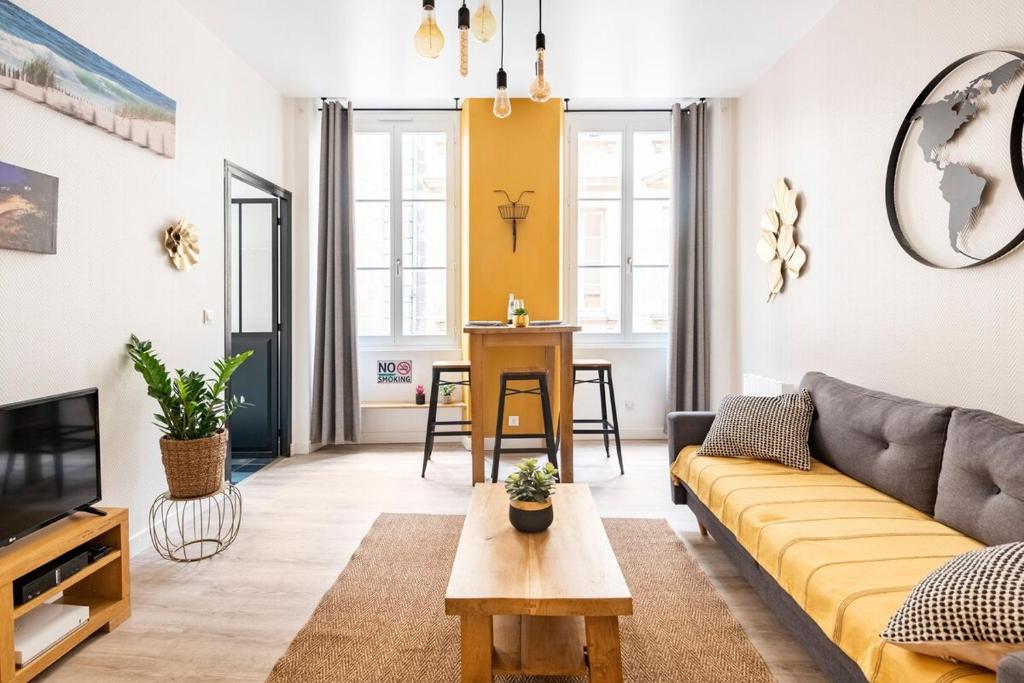 uma sala de estar com um sofá e uma mesa em HOTEL DE VILLE BORDEAUX GRAND T2 STANDING em Bordéus