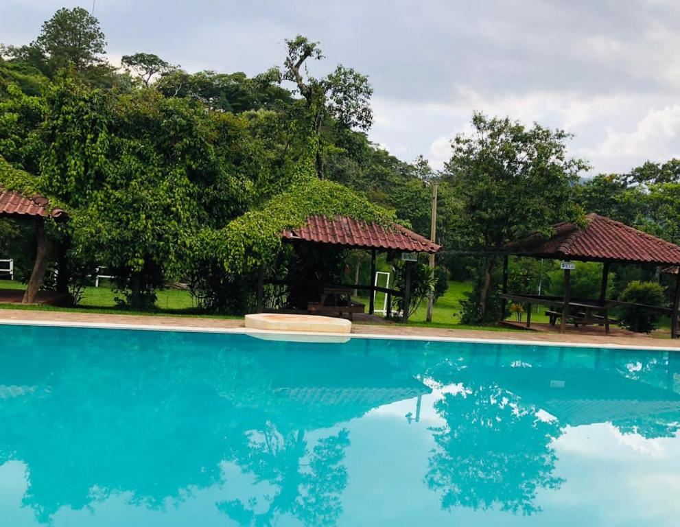 a swimming pool with blue water in front of trees at Finca Esperanza in Arambala