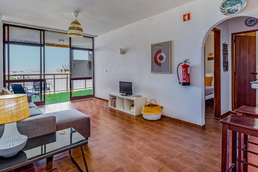 - un salon avec un canapé et une télévision dans l'établissement Bright 1BDR Apartment W/Balcony & Pool by LovelyStay, à Silves