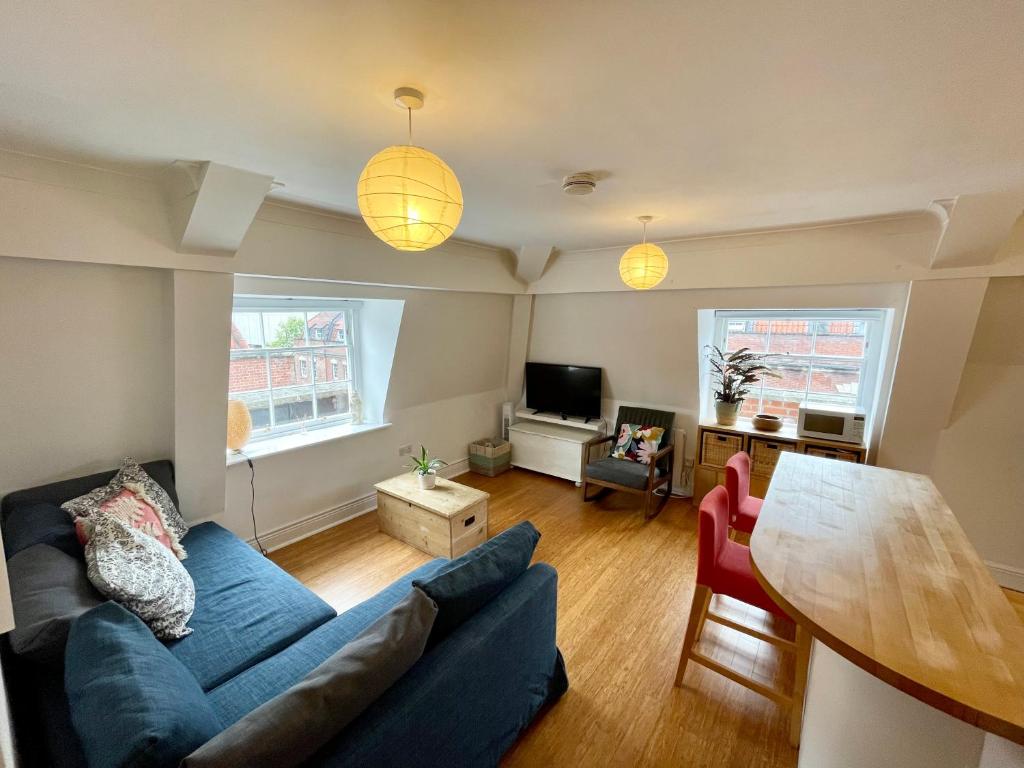 a living room with a blue couch and a table at Bright 1 bed flat near Cabot Circus in Bristol