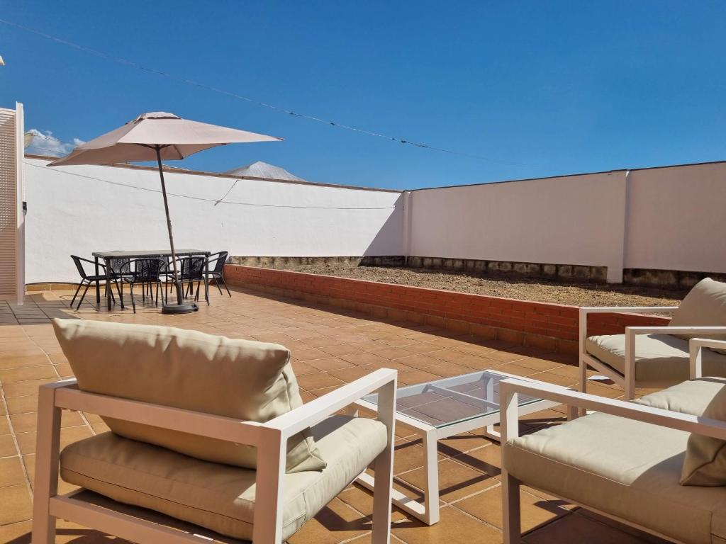 Preciosa vivienda con gran terraza muy luminoso في غرناطة: فناء فيه كراسي وطاولة ومظلة