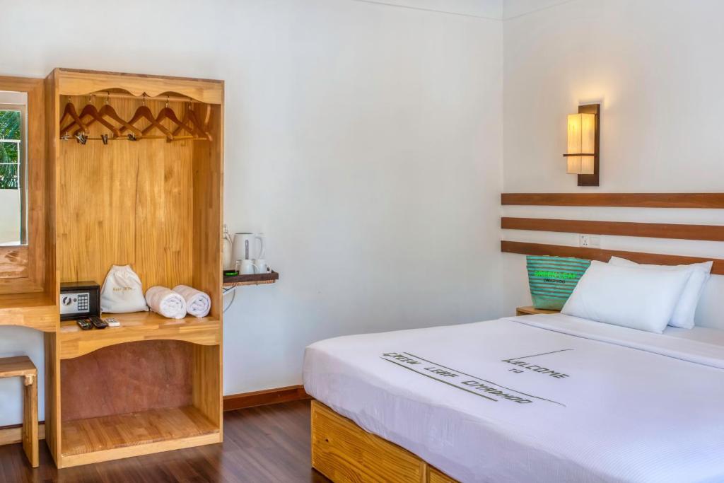 Zimmer mit einem Bett, einem Schreibtisch und einem Bett der Marke sidx sidx sidx. in der Unterkunft Green Leaf Guest House - Omadhoo in Omadhoo