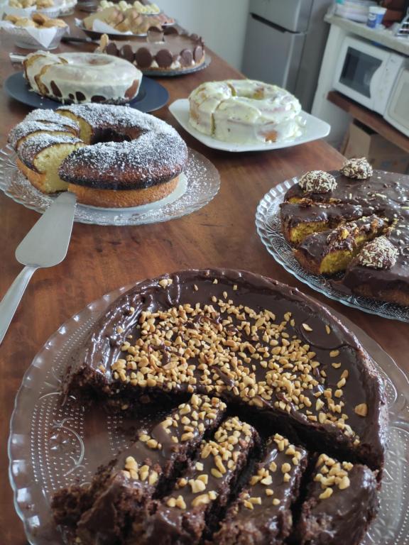 a table topped with different types of cakes on plates at Pedacinho do céu in Tiradentes