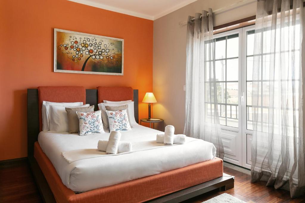 um quarto com uma cama grande e uma janela em Ocean Breeze Villa em Atouguia da Baleia