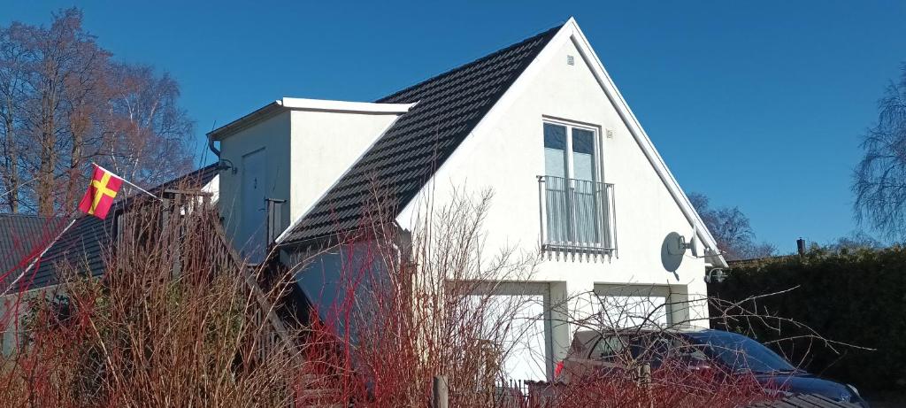 uma casa branca com uma bandeira em frente em Lägenhet Gislövs strandmark em Trelleborg