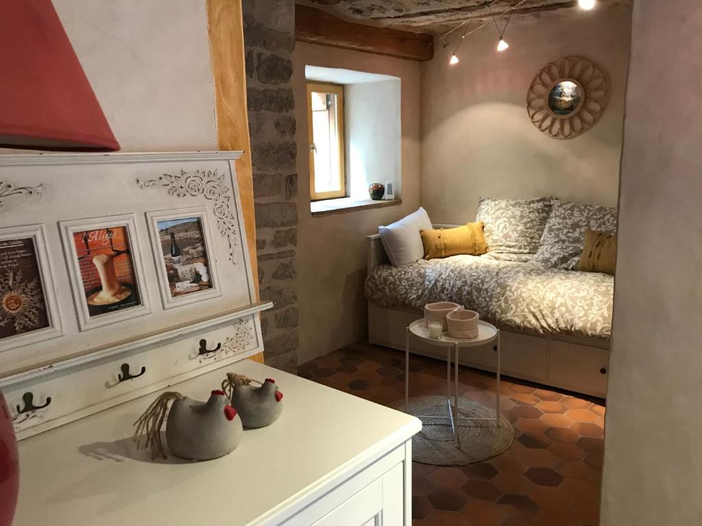 Dormitorio pequeño con cama y mesa en Maison de village au cœur des remparts en Sainte-Eulalie-du-Cernon