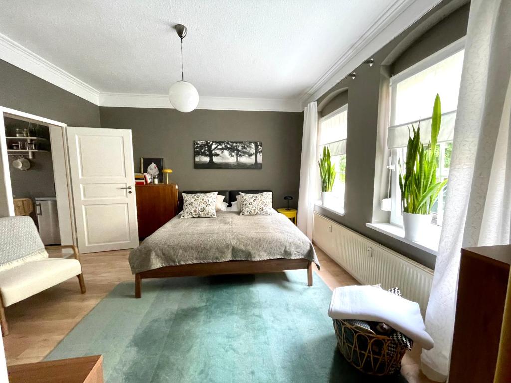 um quarto com uma cama, uma cadeira e janelas em JETHON Appartement in der Gasse em Grimschleben
