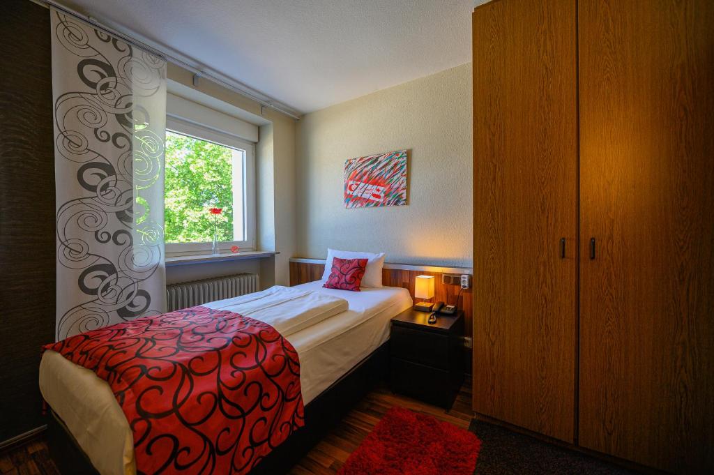 a small bedroom with a bed and a window at Otto's Parkhotel Saarlouis in Saarlouis