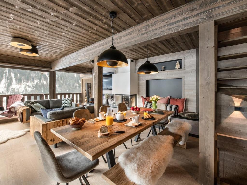 una sala da pranzo e un soggiorno con tavolo e sedie. di Chalet Châtel, 6 pièces, 10 personnes - FR-1-198-213 a Châtel