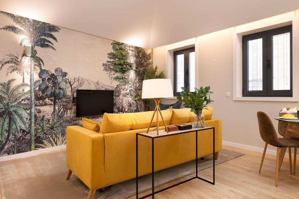 sala de estar con sofá amarillo y TV en Savannah Apartment, by Bolhão Residences, en Oporto