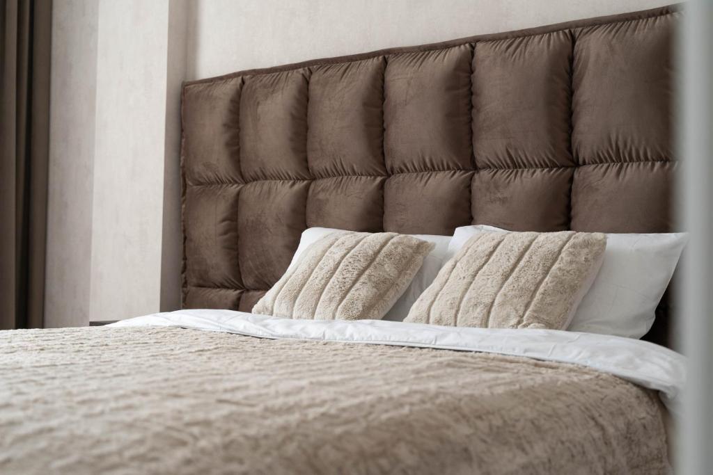 a bed with two pillows on top of it at RentWill apartments Gold in Chişinău