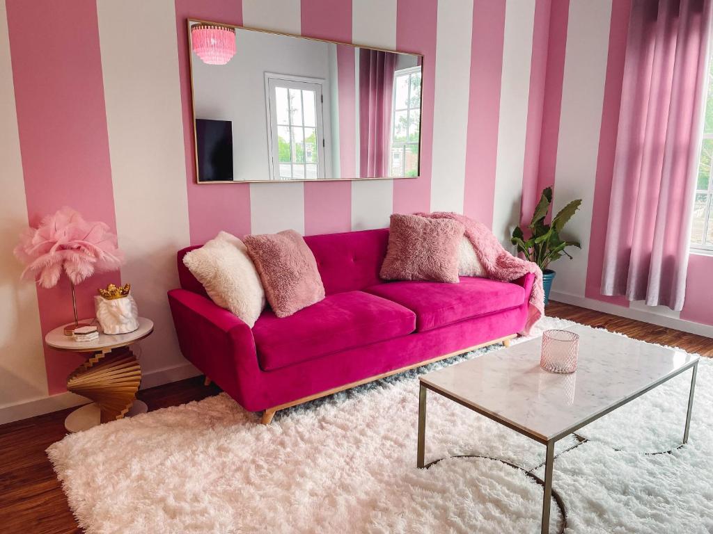 a living room with a purple couch and a mirror at Dolly's Delight - Boutique Bliss Mins From Broadway in Nashville