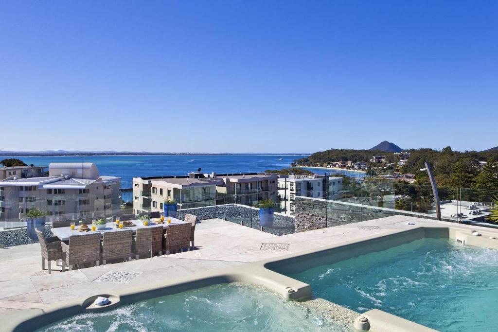 a swimming pool with a view of the ocean at Penthouse Palace - Luxurious Harbourview Location in Nelson Bay