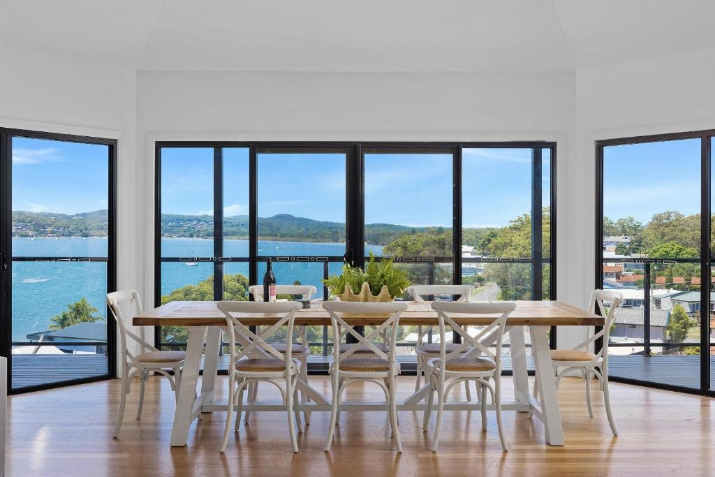 a dining room with a table and chairs at Wanda Point House - pure tranquillity and walk to beach in Salamander Bay