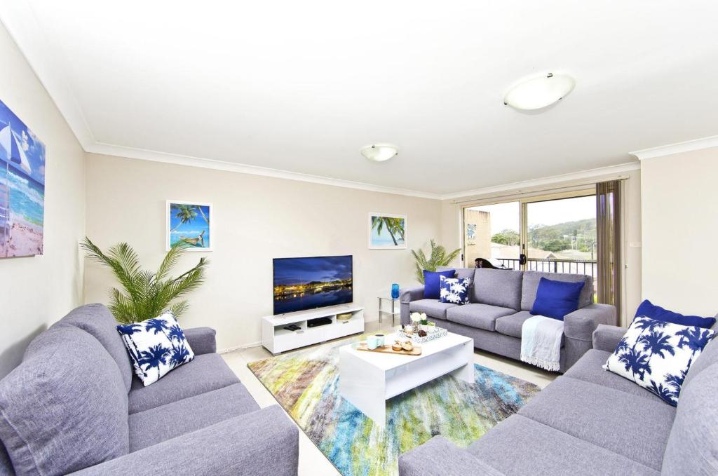 a living room with two couches and a tv at Aqua Lagoon - Great Family Beach Getaway in Nelson Bay