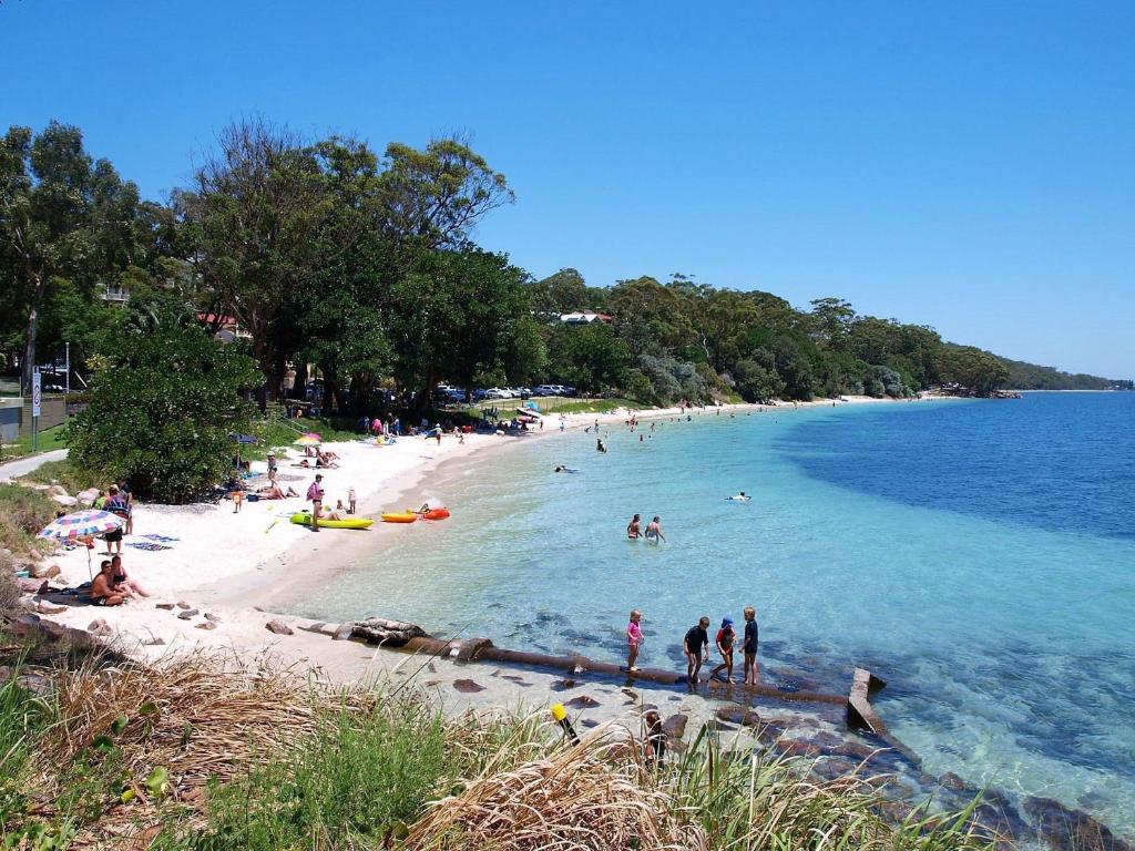 eine Gruppe von Menschen am Strand im Wasser in der Unterkunft Dutchie's Sand & Sea Beach House - easy walk to the beach in Nelson Bay