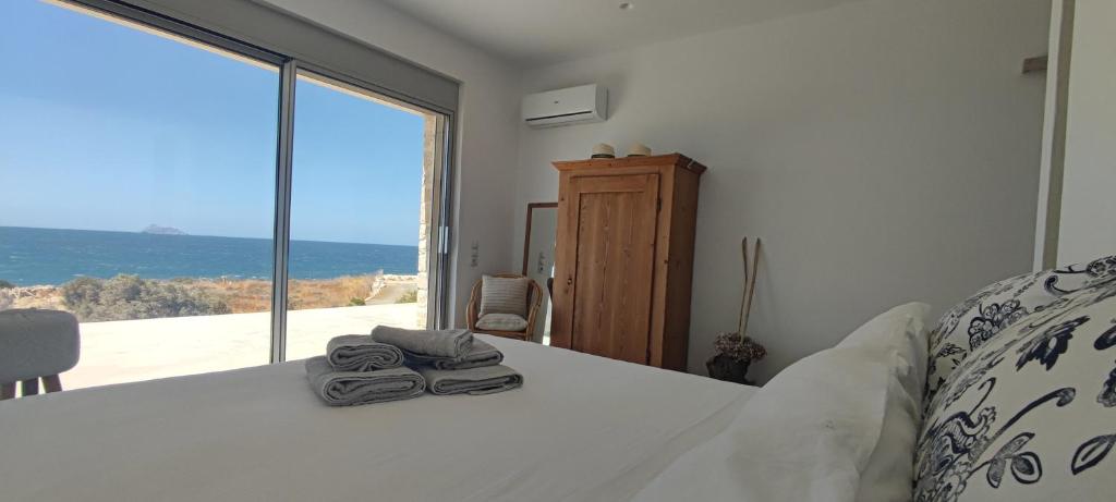 a bedroom with a bed with a view of the ocean at Komos Beach Estate in Kalamaki