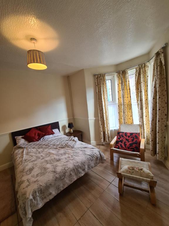 a bedroom with a bed and a chair and a table at Ground floor flat , 31 lena street, easton,bristol avon, uk in Bristol