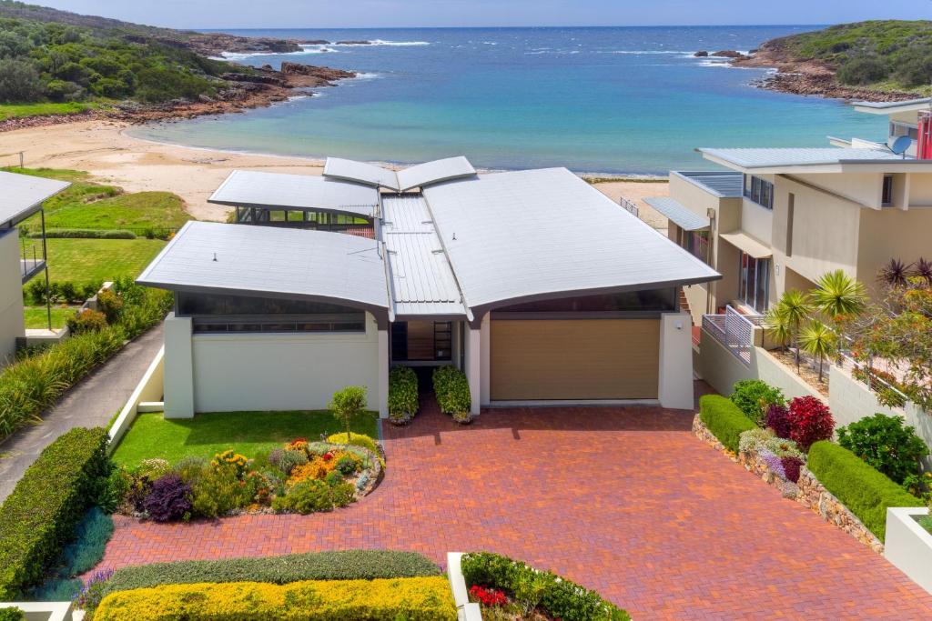 an aerial view of a house with the ocean in the background at Sails on the Beachfront - Exclusive Seaside Home in Anna Bay