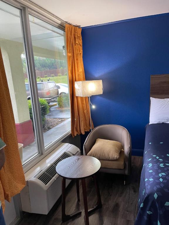 una camera con un letto e una sedia e una finestra di Scottish Inns - Commerce a Commerce