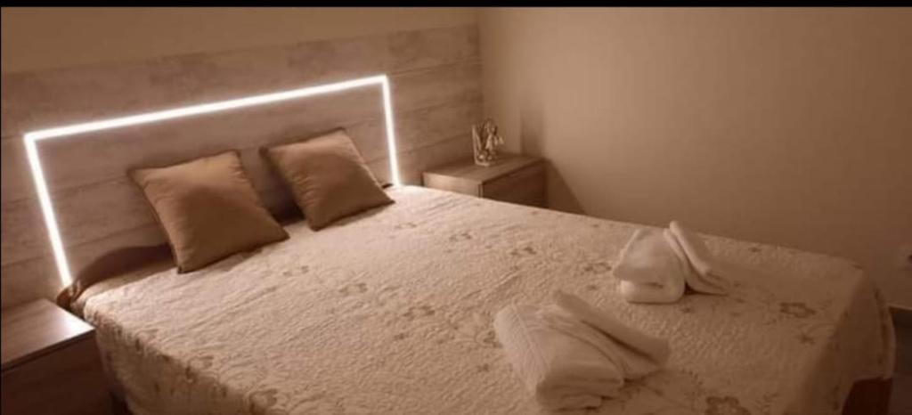 una camera da letto con un letto bianco con due asciugamani di Alojamento Silva a Castelo de Paiva
