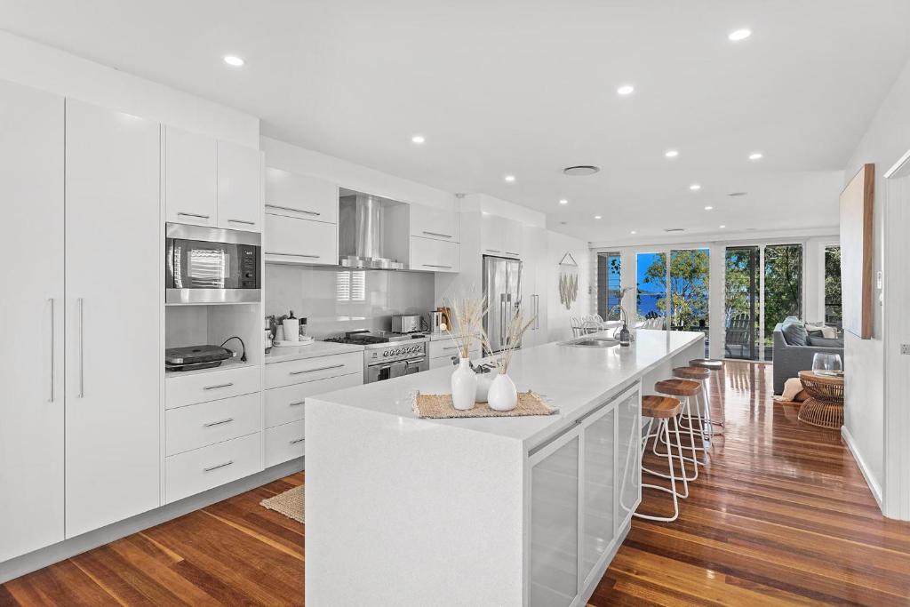 a kitchen with white cabinets and a white counter top at Driftwood in Soldiers Point