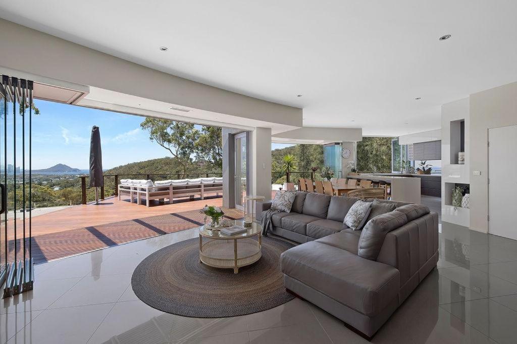 een woonkamer met een bank en een tafel bij Grandview - Luxurious Entertainer with Spectacular Views in Nelson Bay