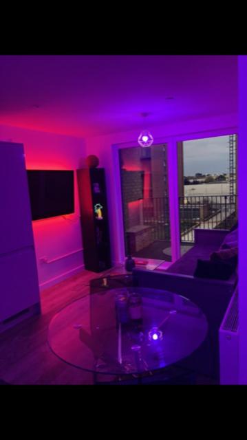 a living room with purple lighting and a table at Perfect spacious 1 bedroom flat with night lights in Hayes