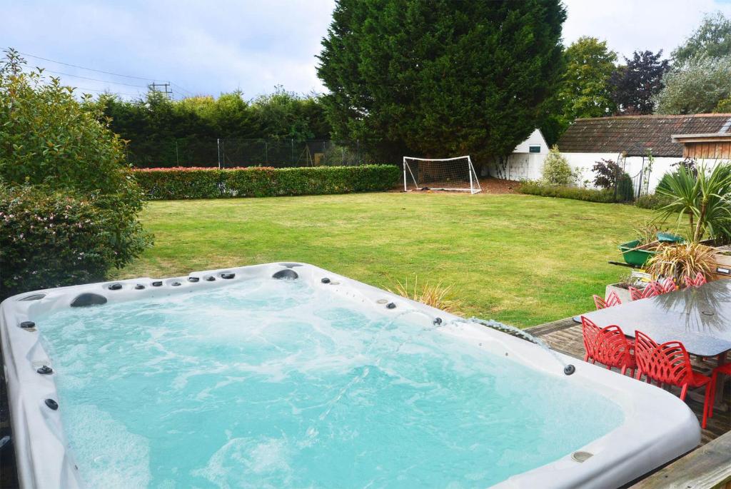 una bañera de hidromasaje en un patio con una pelota de fútbol en Drystone Manor - Swim Hot Tub, Tennis, Gatherings en Iron Acton