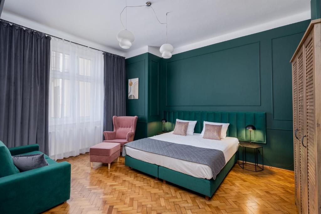 - une chambre avec un lit et un mur vert dans l'établissement Wawel Boutique Residence - Krakow Old Town, à Cracovie