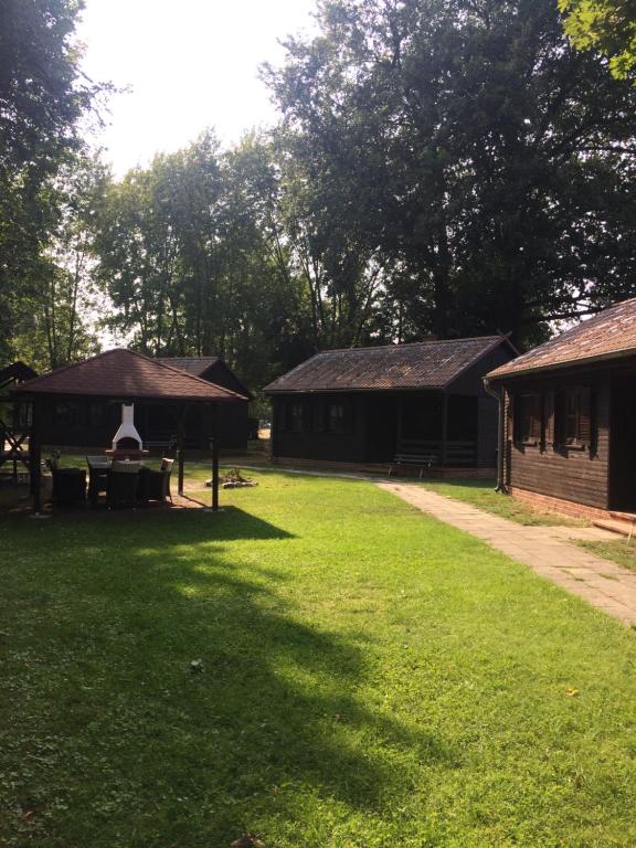 2 bâtiments avec une table de pique-nique dans l'herbe dans l'établissement Bungalowdorf Lübben, à Lübben